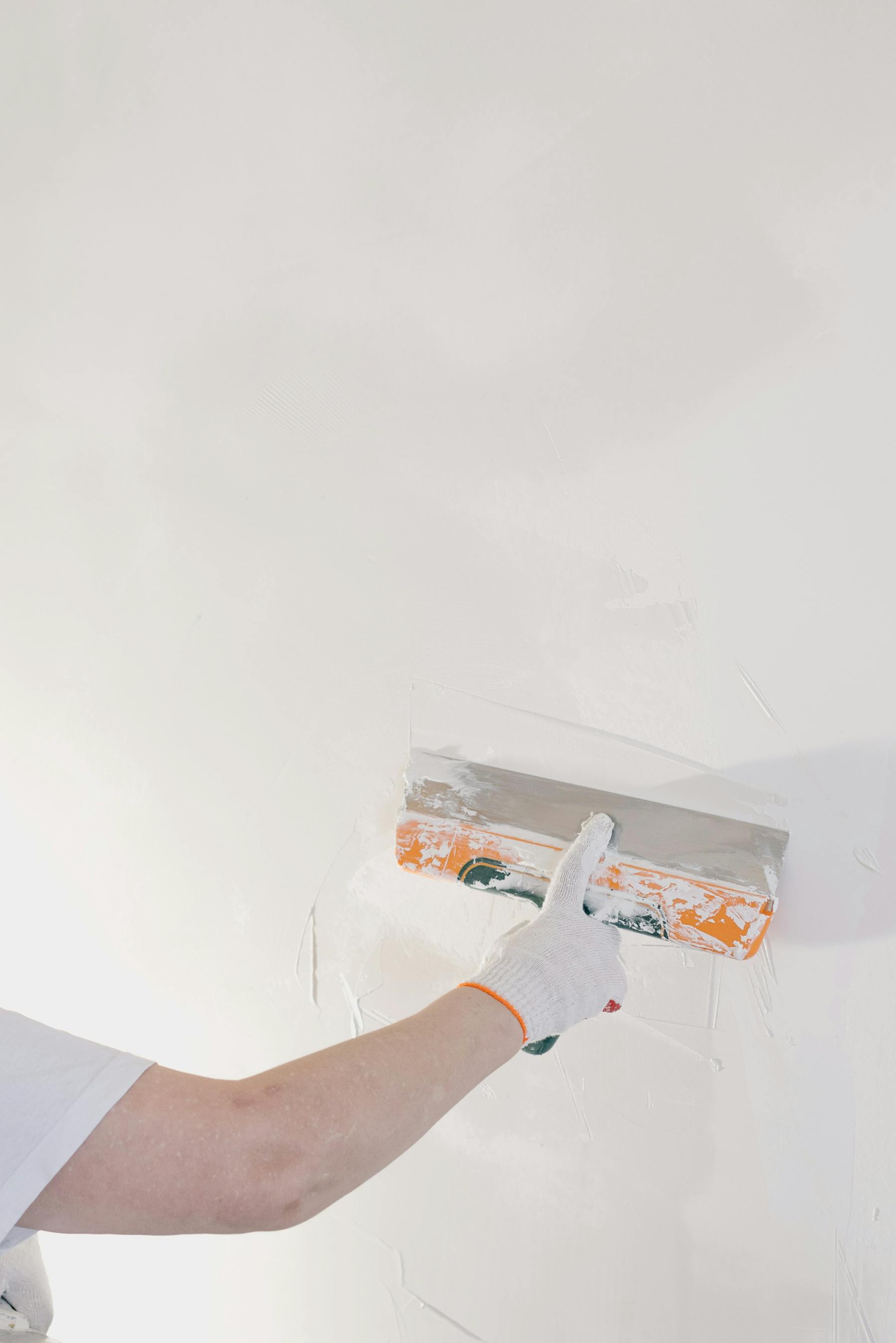 Application d'enduit à la spatule sur un mur intérieur